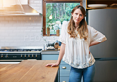 Buy stock photo Portrait of a smiling young woman standing in her kitchen