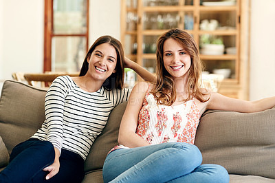 Buy stock photo Portrait of two young friends sitting together on the living room
