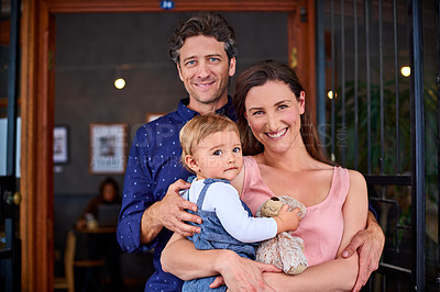 Buy stock photo Portrait of smiling couple and their little girl standing in front of their bakery