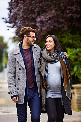 Buy stock photo Shot of a young pregnant woman and her husband enjoying a walk together