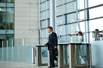 Buy stock photo Shot of businesspeople walking through the lobby of an office building
