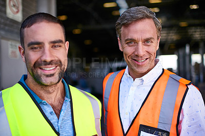 Buy stock photo Portrait of two smiling workers standing in a large warehouse