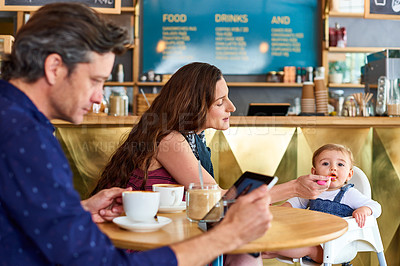 Buy stock photo Shot of a couple and their baby daughter sitting at a table in a cafe
