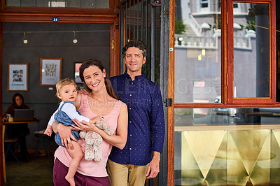 Buy stock photo Portrait of smiling couple and their little girl standing in front of their bakery