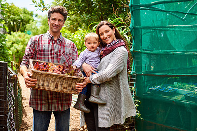 Buy stock photo Portrait of a couple with their baby girl standing in their organic garden