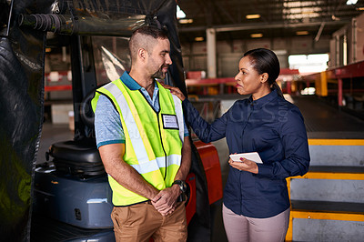 Buy stock photo Shot of two coworkers talking together inside a large warehouse