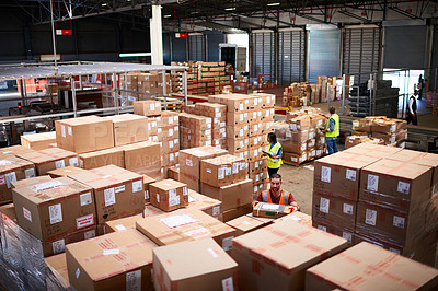 Buy stock photo Shot of people at work in a large warehouse full of boxes