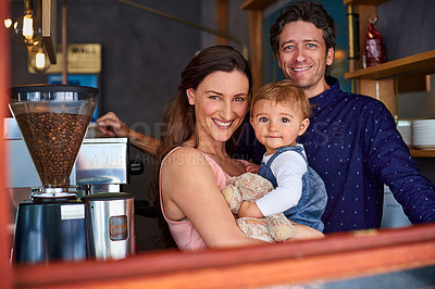 Buy stock photo Portrait of smiling couple and their little girl standing in the window of their bakery