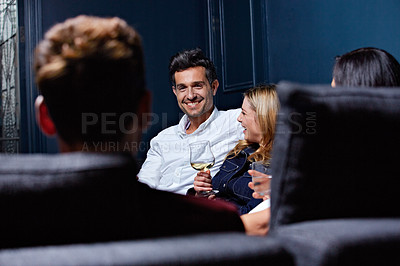 Buy stock photo Shot of a group of friends enjoying a night in together at home