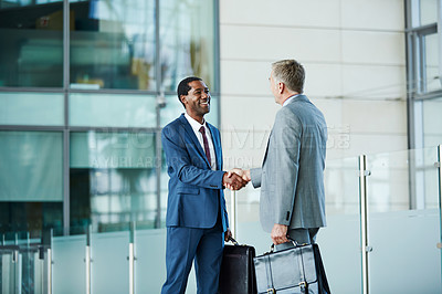 Buy stock photo Shot of of two businessmen shaking hands in the lobby of an office building