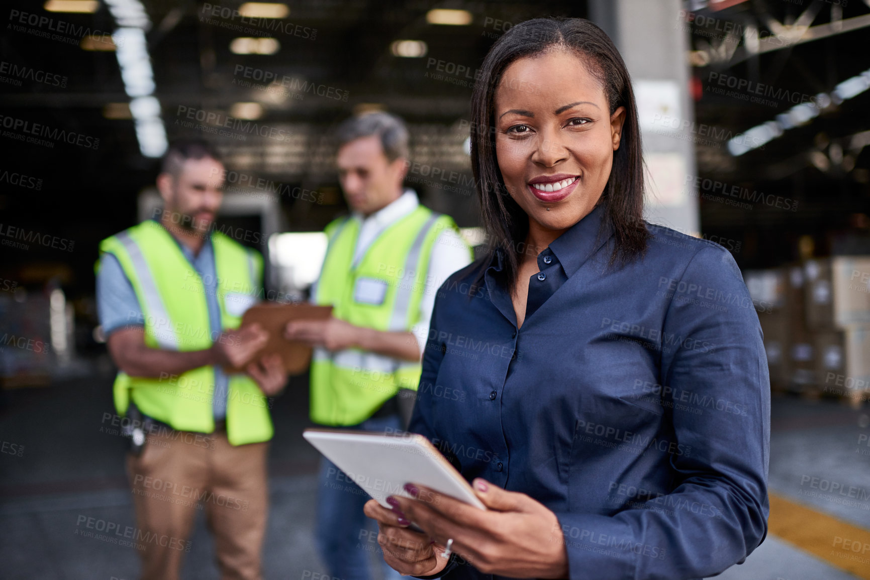 Buy stock photo Portrait of a warehouse manager holding a digital tablet with workers in the background