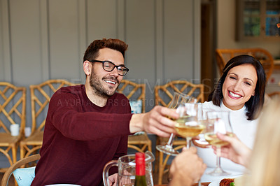 Buy stock photo Shot of a group of friends toasting together over dinner