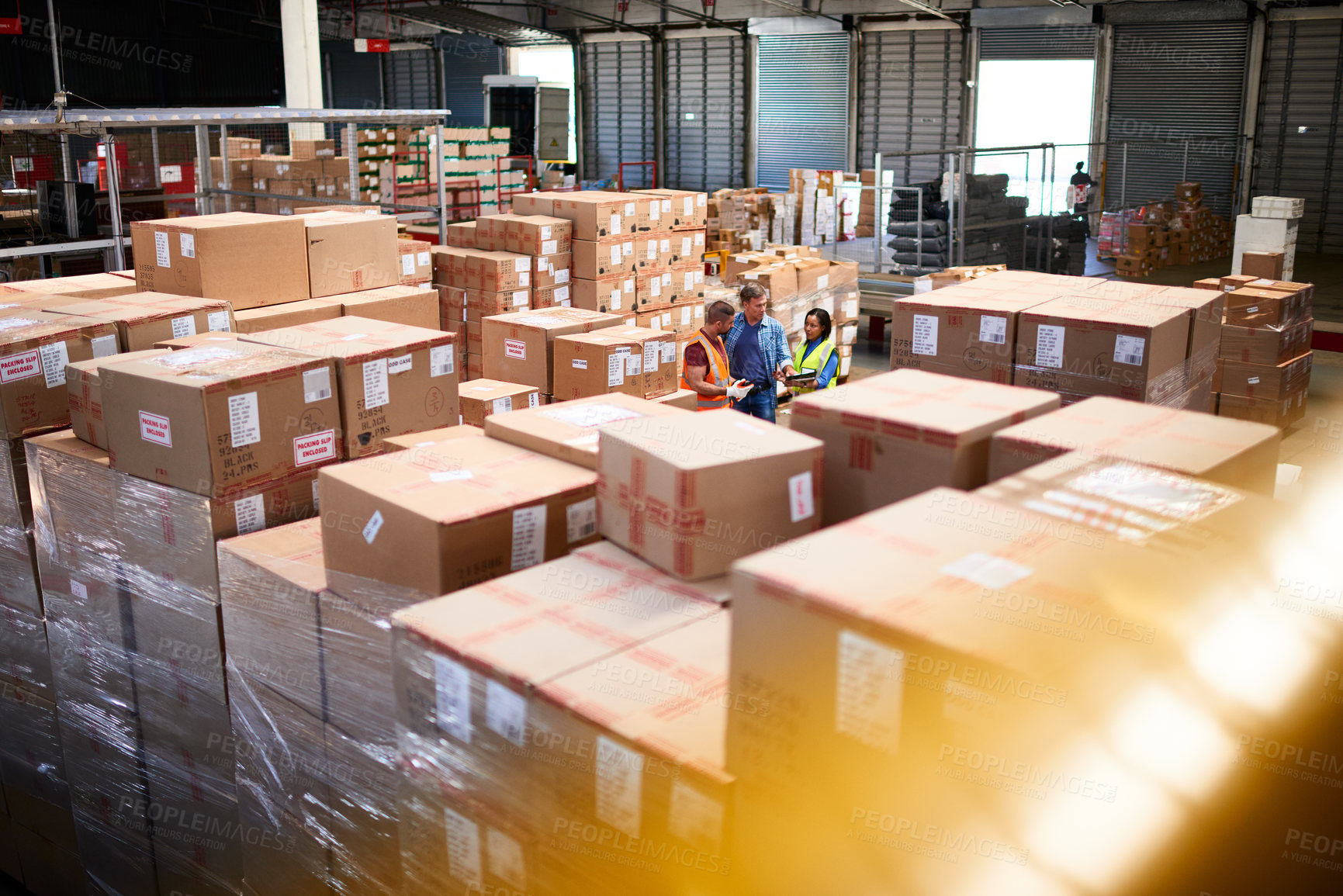 Buy stock photo Shot of people at work in a large warehouse full of boxes