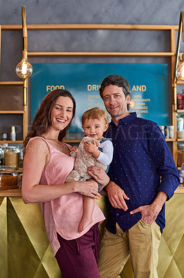 Buy stock photo Portrait of a smiling couple and their little girl standing in their bakery