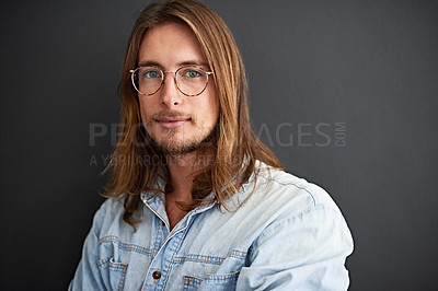 Buy stock photo Studio portrait of a young man standing against a gray background
