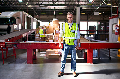 Buy stock photo Portrait of a smiling worker standing in a large warehouse full of boxes