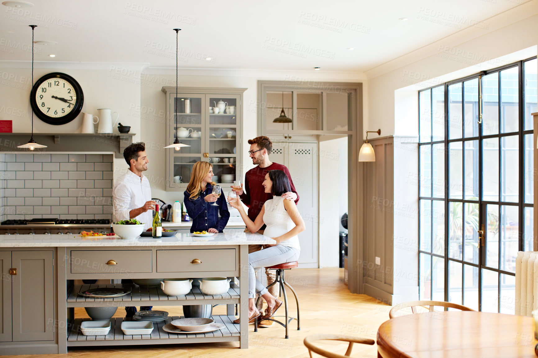 Buy stock photo Shot of two couples talking and toasting together while enjoying a get-together at home