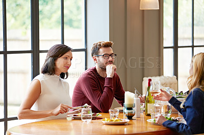 Buy stock photo Shot of a group of friends enjoying a home-cooked dinner together