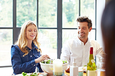 Buy stock photo Shot of a group of friends enjoying a home-cooked dinner together