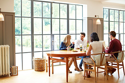 Buy stock photo Shot of a group of friends enjoying a home-cooked dinner together