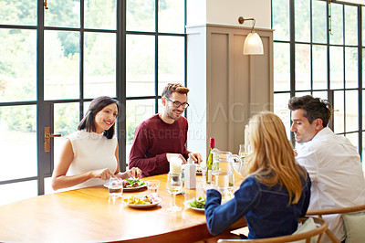 Buy stock photo Shot of a group of friends enjoying a home-cooked dinner together