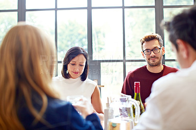 Buy stock photo Shot of a group of friends enjoying a home-cooked dinner together
