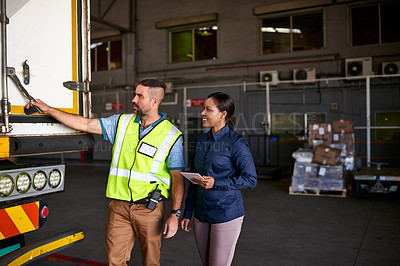Buy stock photo Shot of a manager holding a digital tablet and talking to a truck driver on the loading dock of a large warehouse