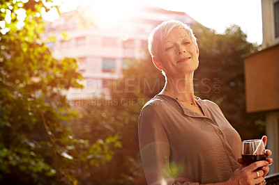Buy stock photo Portrait of an attractive mature woman standing outside with a glass of wine