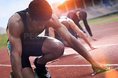 Buy stock photo Shot of a group of runners crouching in starting blocks before a race on a running track