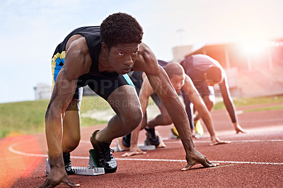 Buy stock photo Shot of a group of runners crouching in starting blocks before a race on a running track
