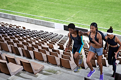 Buy stock photo Shot of a group of young athletes running up stairs in a sports stadium