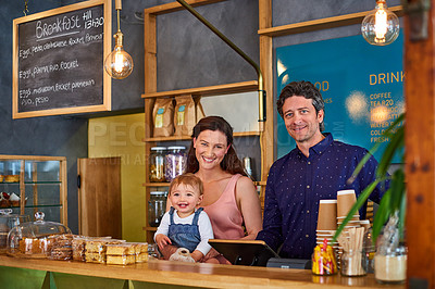 Buy stock photo Portrait of a smiling couple and their little girl standing in their bakery