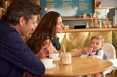 Buy stock photo Shot of a couple and their baby daughter sitting at a table in a cafe