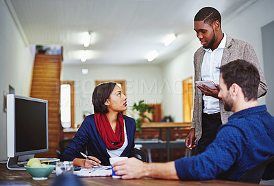 Buy stock photo Shot of a young man leading a meeting with coworkers in an office