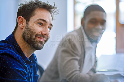 Buy stock photo Shot of two colleagues sitting together while working in an office