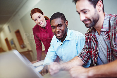 Buy stock photo Shot of a group of businesspeople working together on a laptop in an office