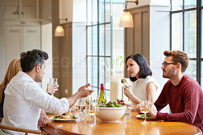 Buy stock photo Shot of a group of friends enjoying a home-cooked dinner together