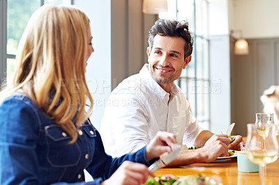 Buy stock photo Shot of a young couple enjoying a home-cooked dinner together