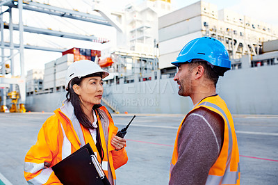 Buy stock photo Shot of two coworkers in protective workwear standing on a large commercial dock