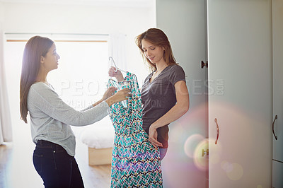 Buy stock photo Shot of a young woman helping her friend choose something to wear
