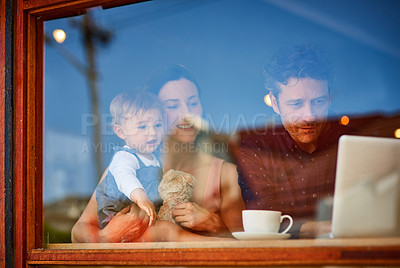 Buy stock photo Shot of smiling couple and their little girl standing in the window of their bakery