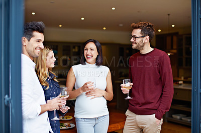 Buy stock photo Shot of a group of friends drinking wine and talking together at a get-together