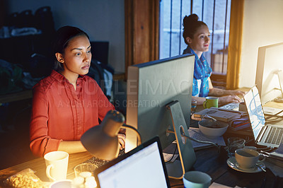 Buy stock photo Shot of a young woman working on a computer in an office in the evening