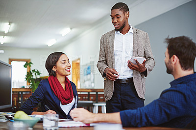 Buy stock photo Shot of a young man leading a meeting with coworkers in an office