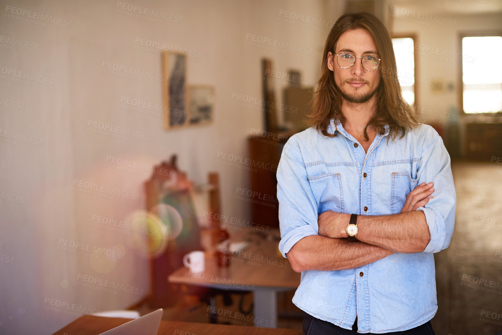 Buy stock photo Portrait of a focused young designer standing with his arms crossed in an office