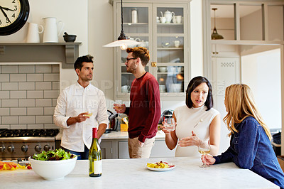 Buy stock photo Shot of two young couples having a chat while chilling in the kitchen