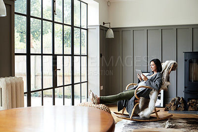 Buy stock photo Shot of an attractive and pregnant young woman relaxing on a rocking chair