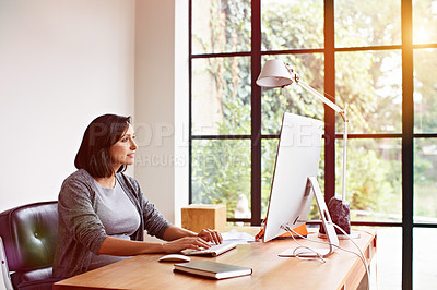 Buy stock photo Shot of an attractive young woman working at home on her laptop