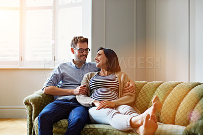 Buy stock photo Shot of an affectionate young couple relaxing on the sofa at home