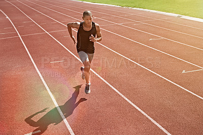 Buy stock photo Shot of a young athlete out running on the track